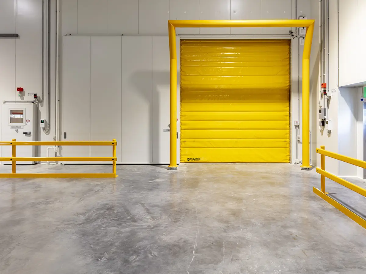 A closed yellow Movichill thermal Movidor Rapid roller door on a freezer inside a factory of DHL Brisbane Airport