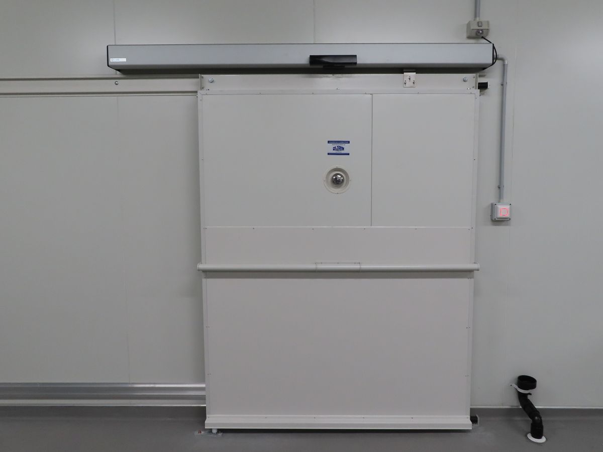 A door to a coldroom with an automatic operator on top.