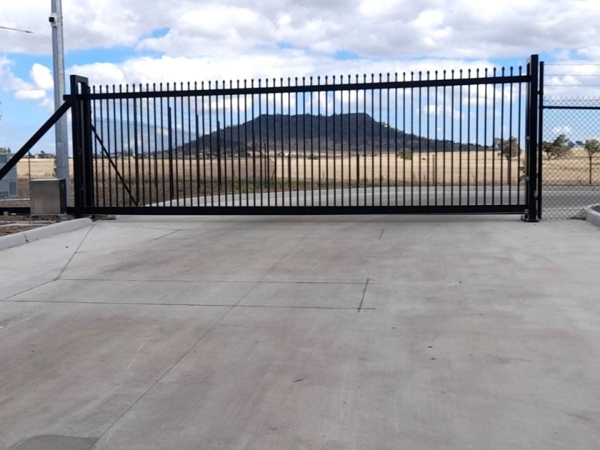 A closed automatic gate at exit of an industrial park of Toowoomba Regional Council, cantilever automatic gate shown with magnetic ground loop.