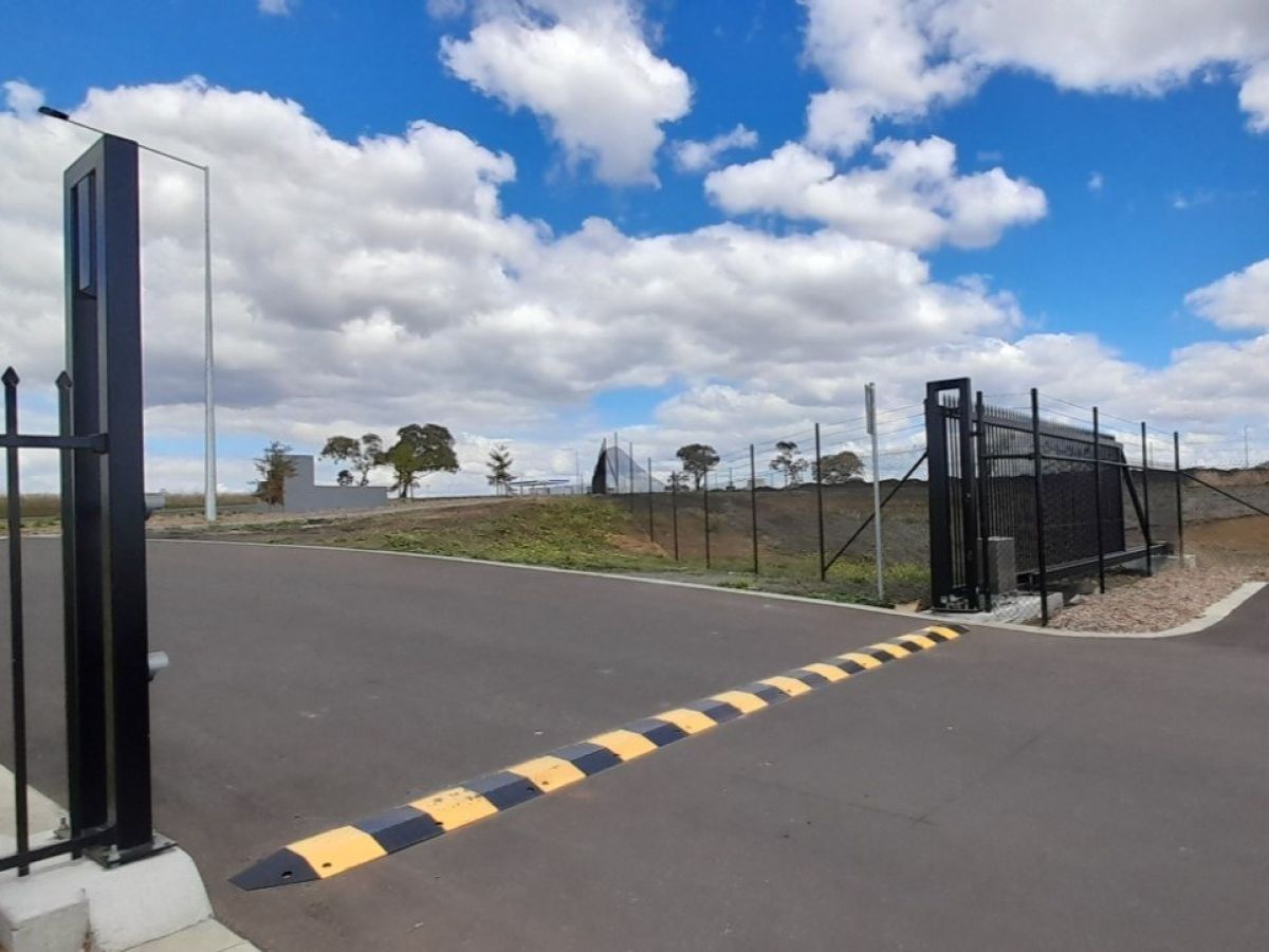 A cantilever automatic gate shown open at an industrial park of the Toowoomba Regional Council. featuring magnetic ground loops for vehicle protection.