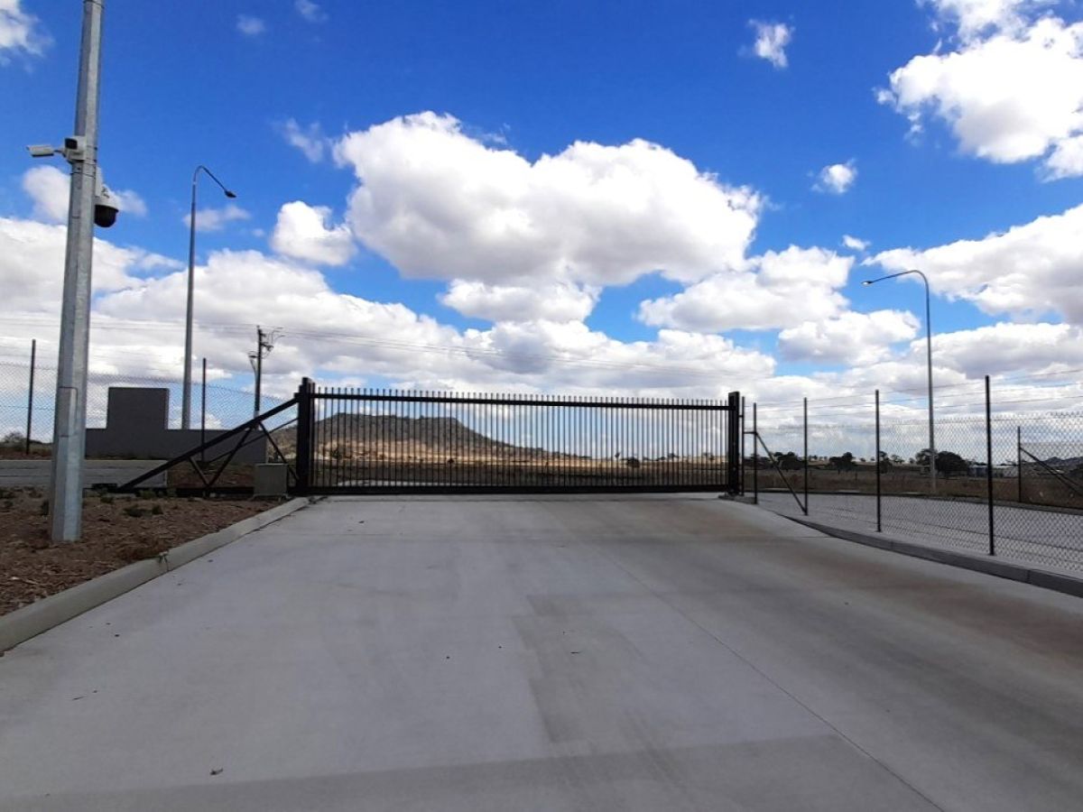 A closed automatic gate at entry of an industrial park of Toowoomba Regional Council, cantilever gate option shown with incorporated magnetic ground loops