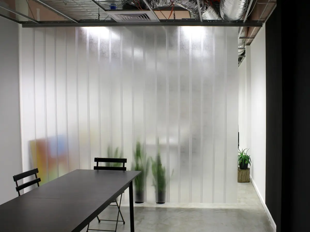 Tailor-made PVC strip curtain separating rooms in an indoor commercial workspace.