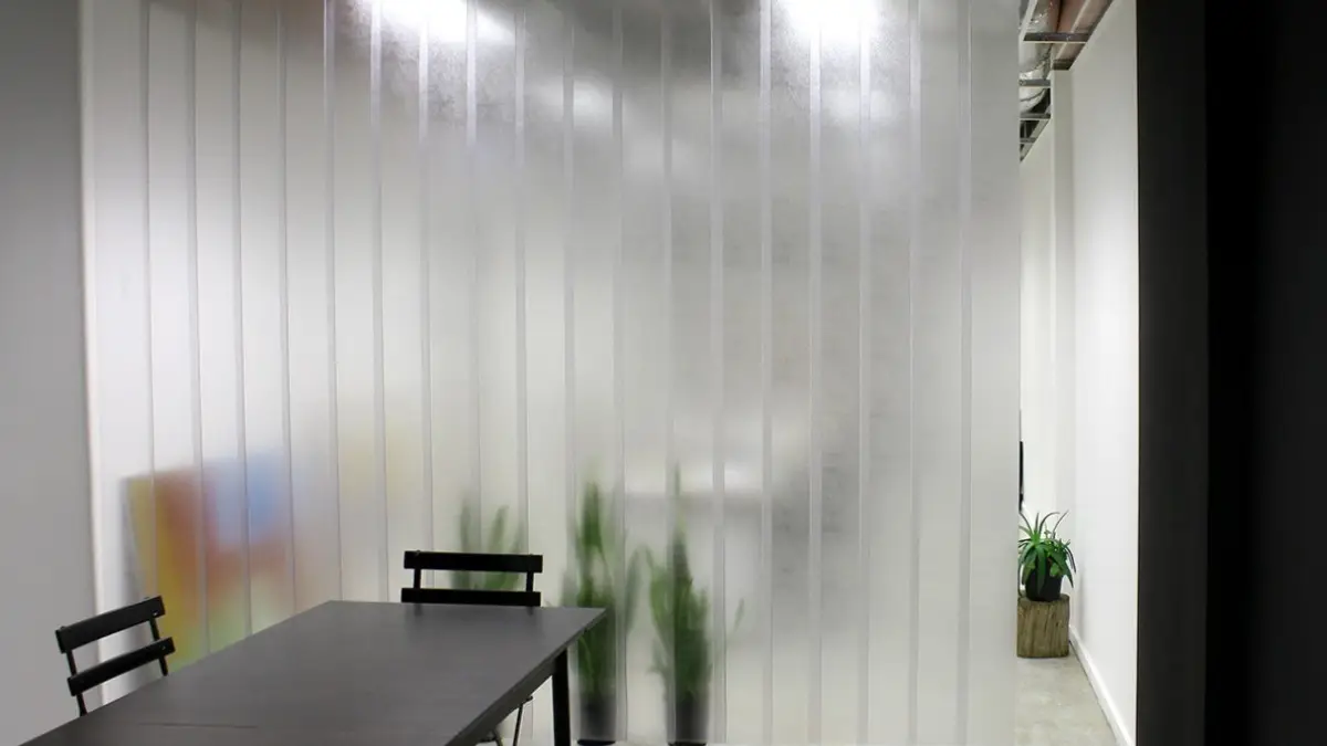 Tailor-made PVC strip curtain separating rooms in an indoor commercial workspace.