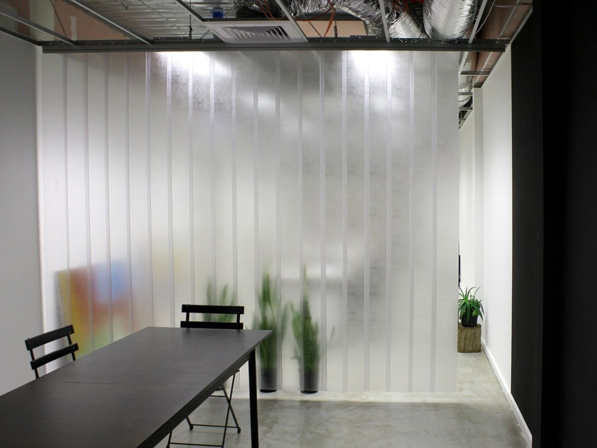Strip curtains separating rooms in an indoor workspace.