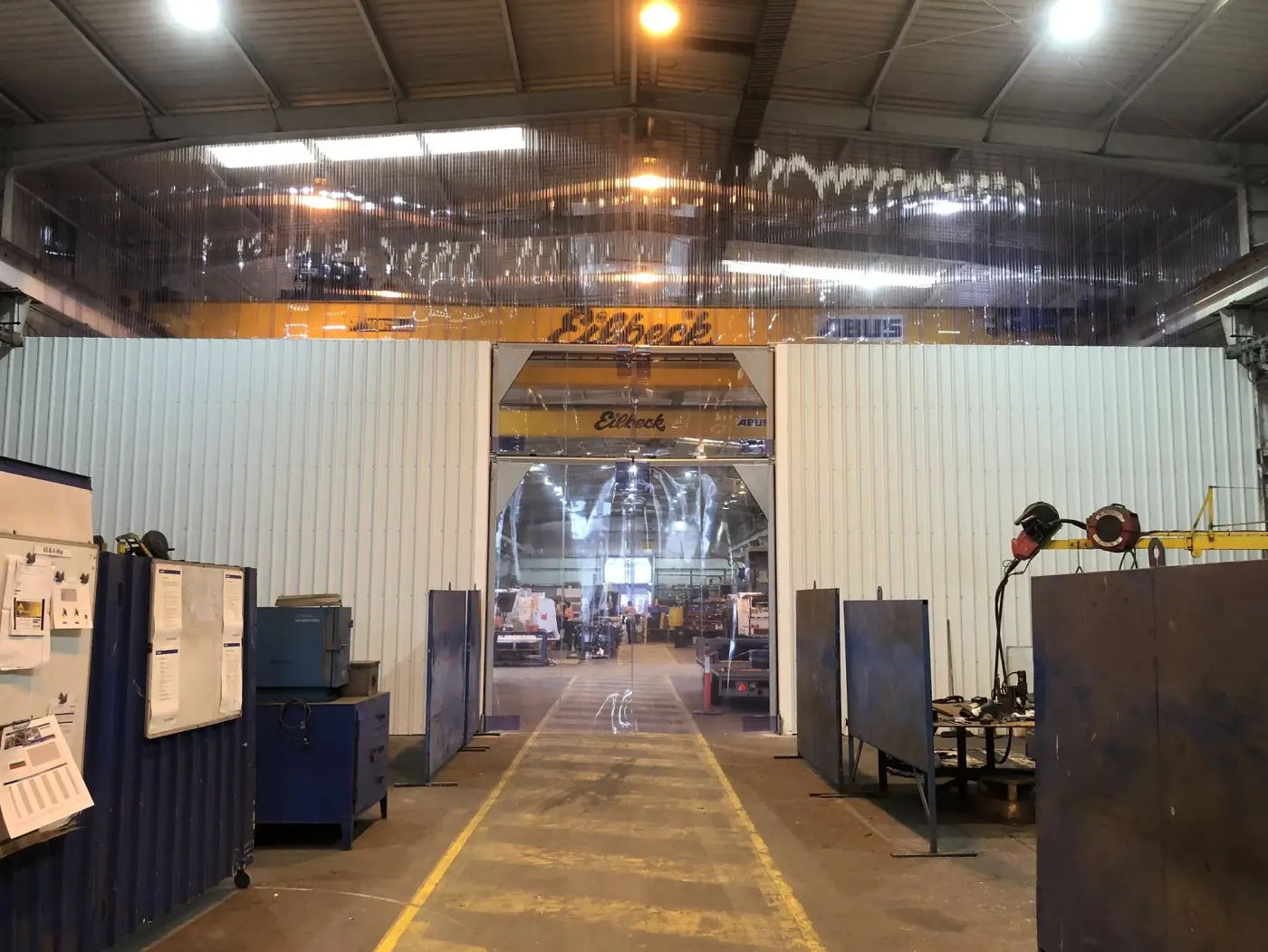 Customised PVC strip curtain and mounting system, effective barrier between sections in an industrial factory.