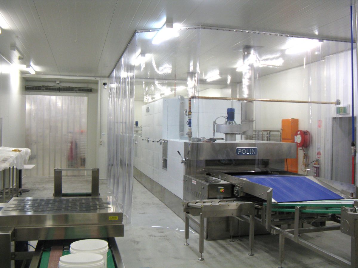 A PVC strip curtain screen; industrial clear plastic strip curtain used to protect factory equipment in commercial food processing facility of Allied Mills