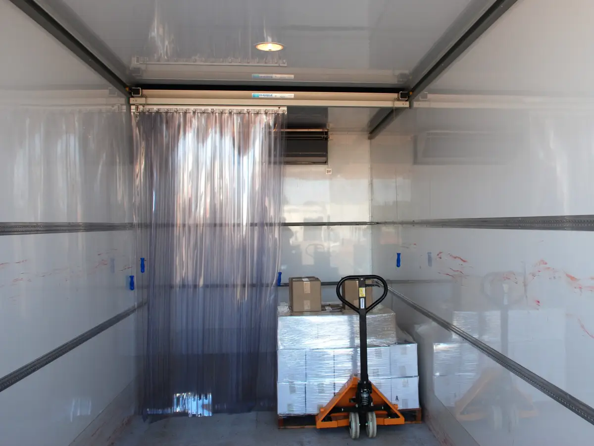 A Compass system of PVC strip curtains showing the sliding beams inside a refrigerated truck.