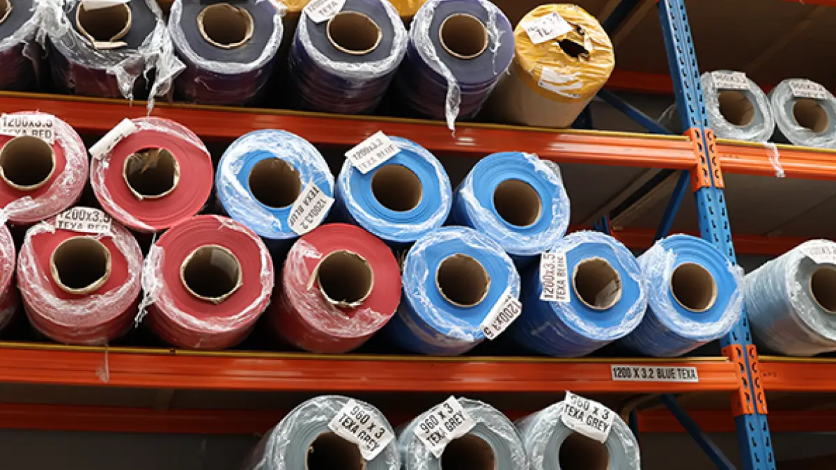 Bulk PVC strip curtain rolls in red, blue, yellow, and grey.