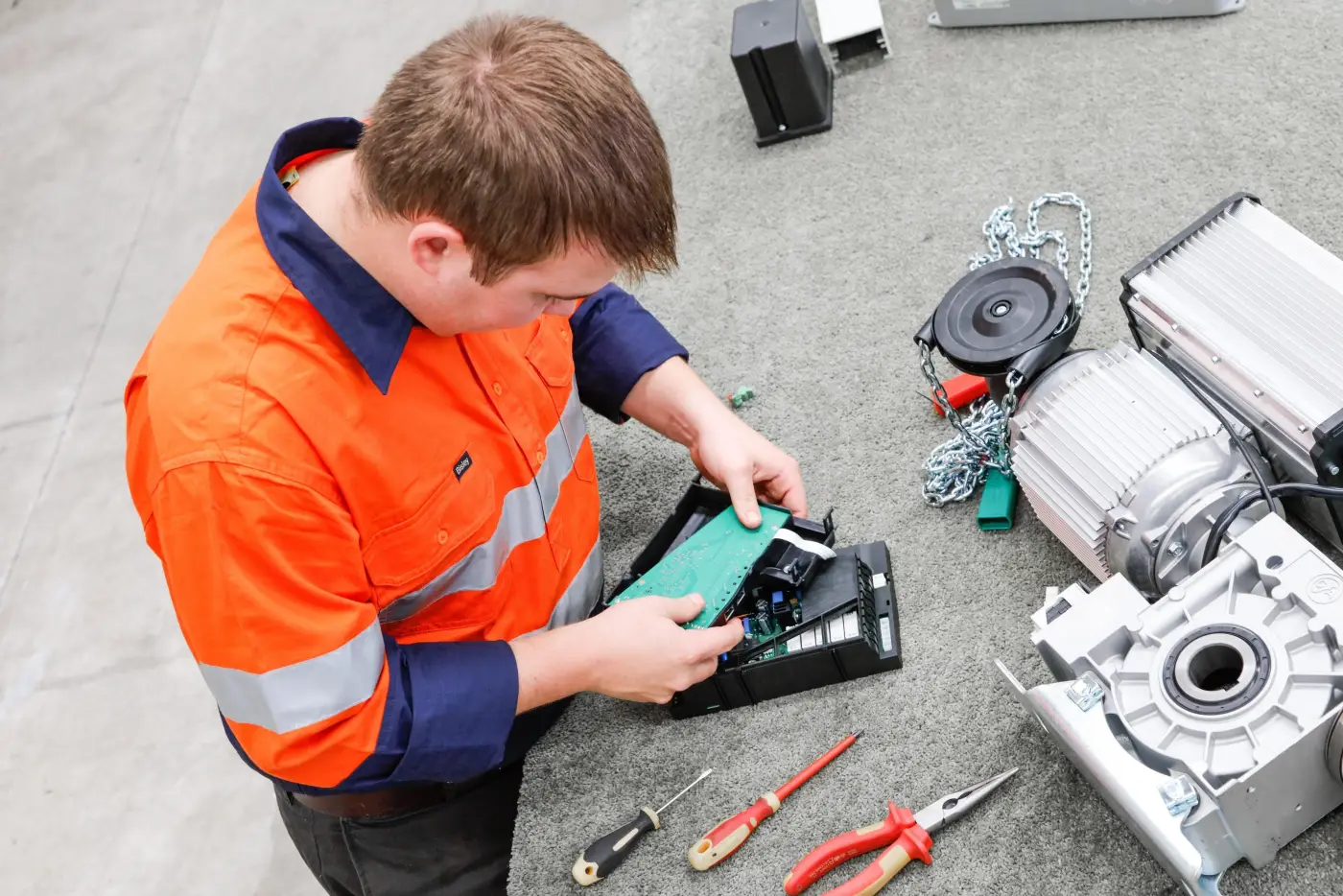 Australian Coldshield service & maintenance employee with tools fixing the electrical component of a motor.