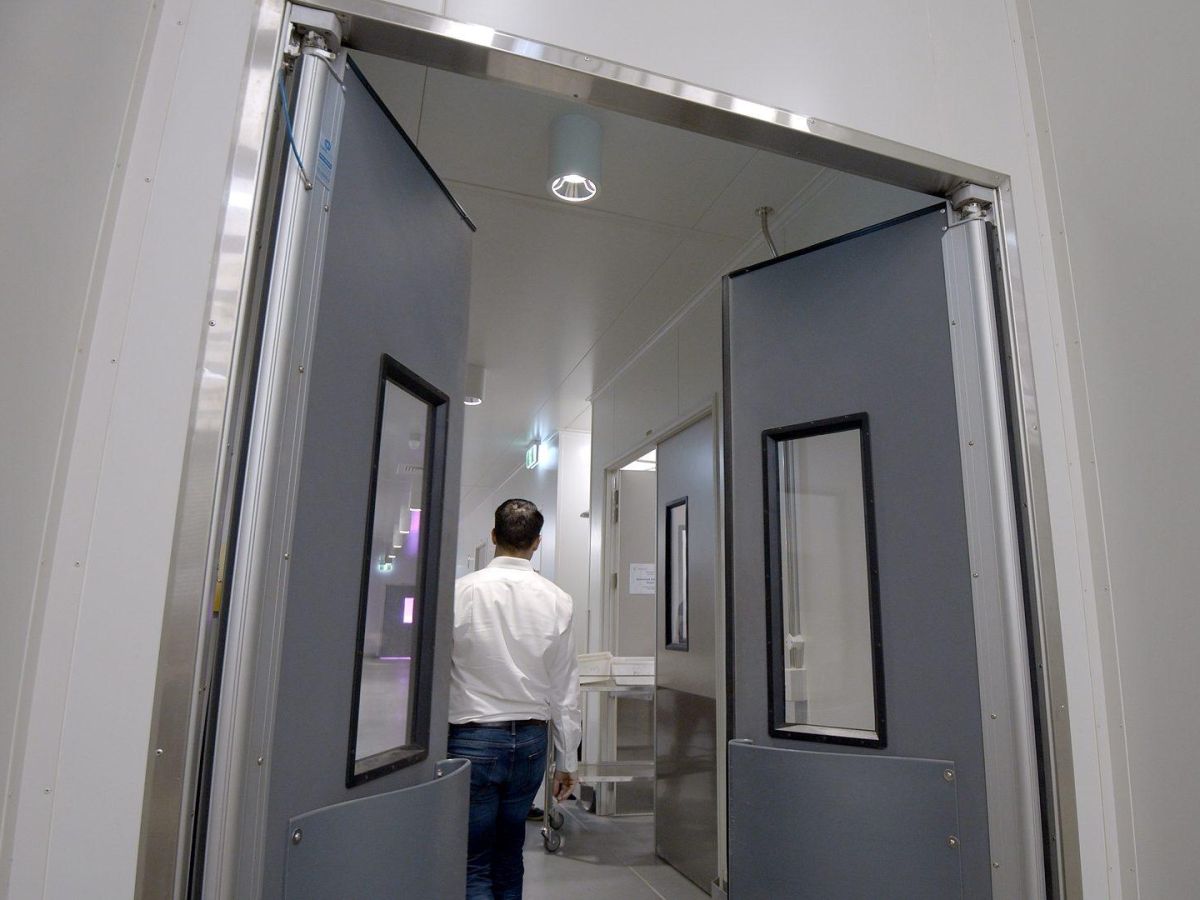 A man walking through swinging traffic doors in a laboratory of USQ