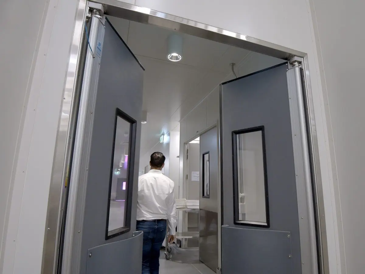 A man walking through swinging traffic doors in a laboratory of USQ
