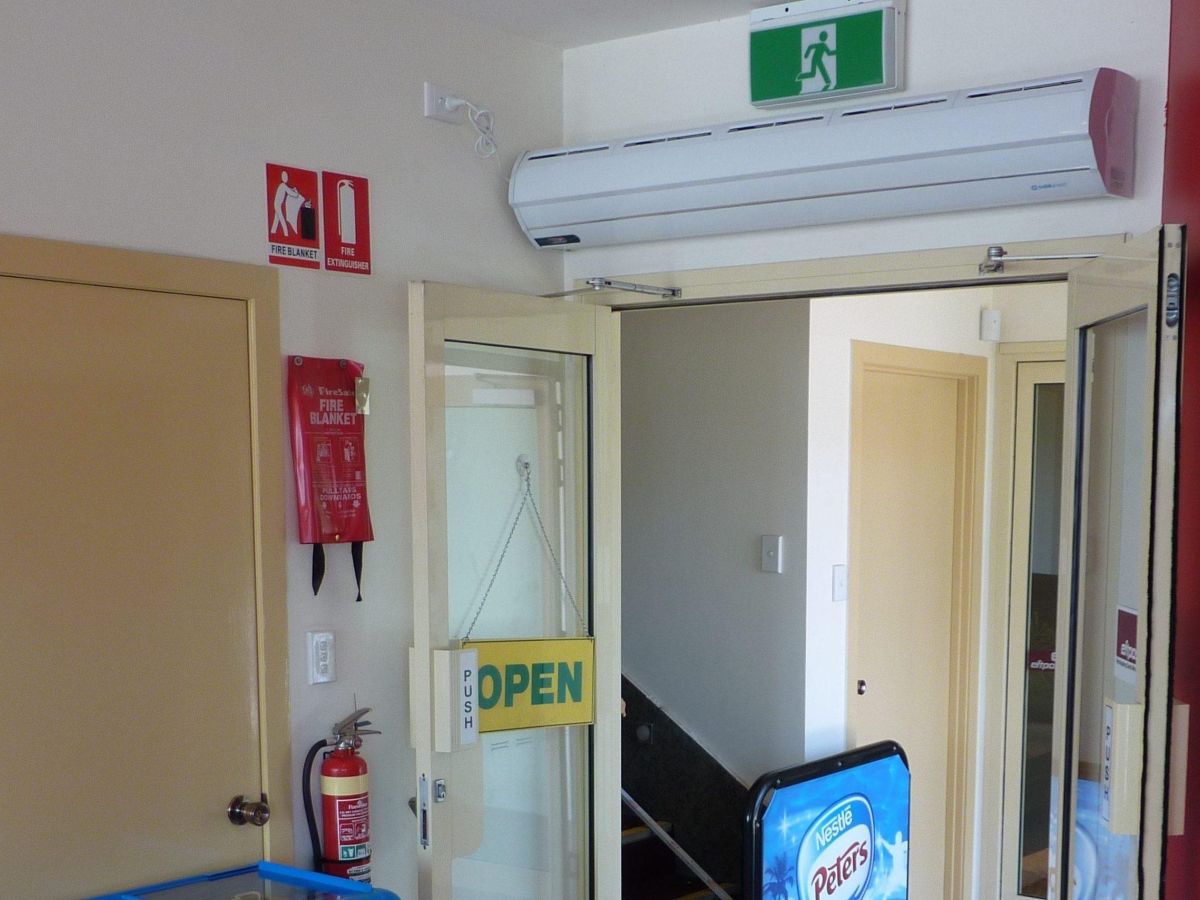 A commercial air curtain above an open doorway of a café.