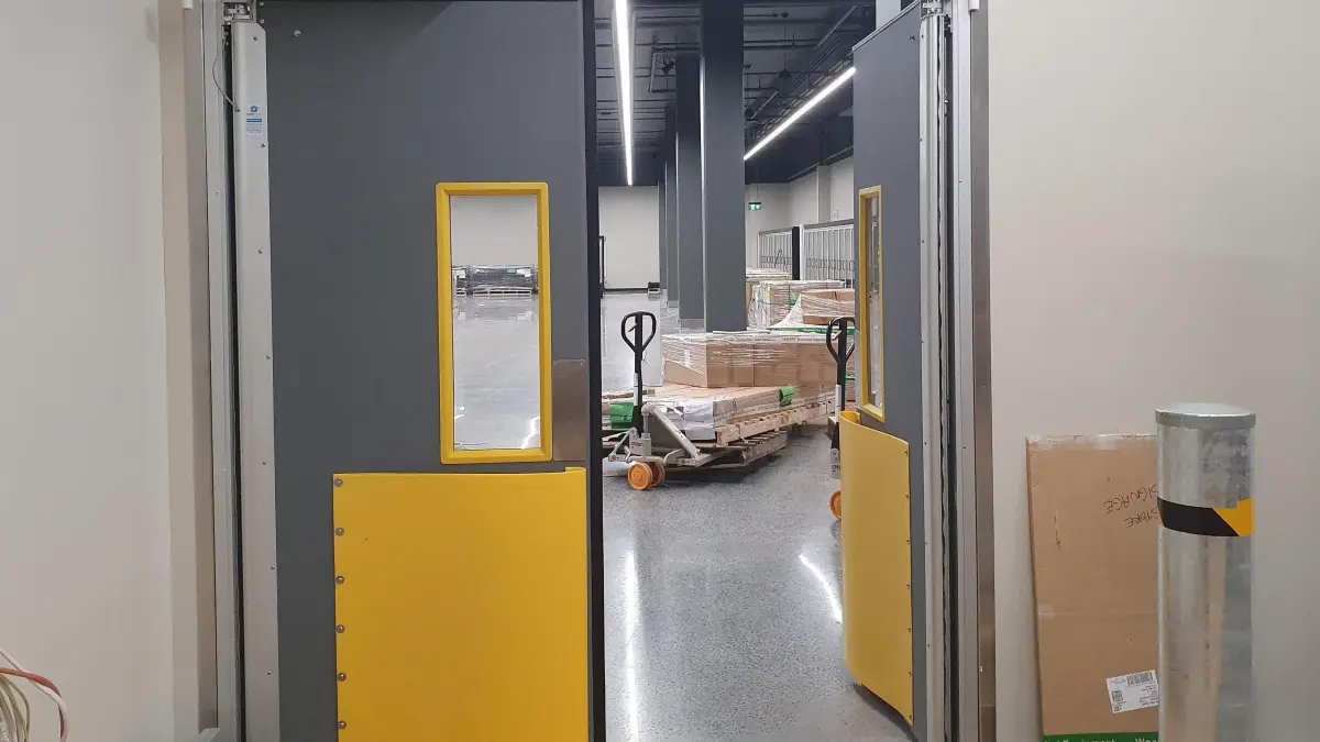 An open Coldshield 4500 Series thermal swing traffic door leading through to supermarket backroom iof WW West End