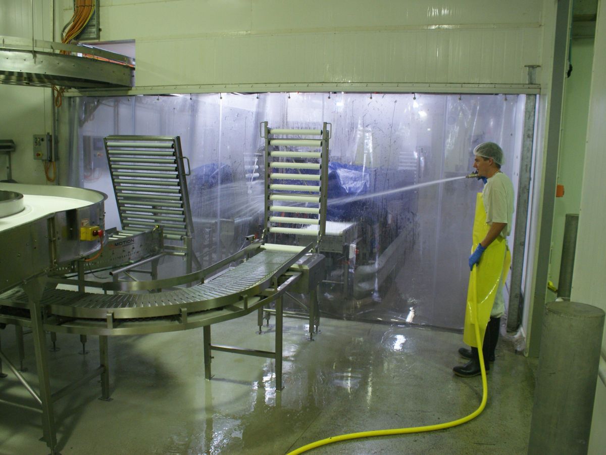 A industrial PVC screen; clear plastic curtains separating a wash down area in a commercial food processing factory