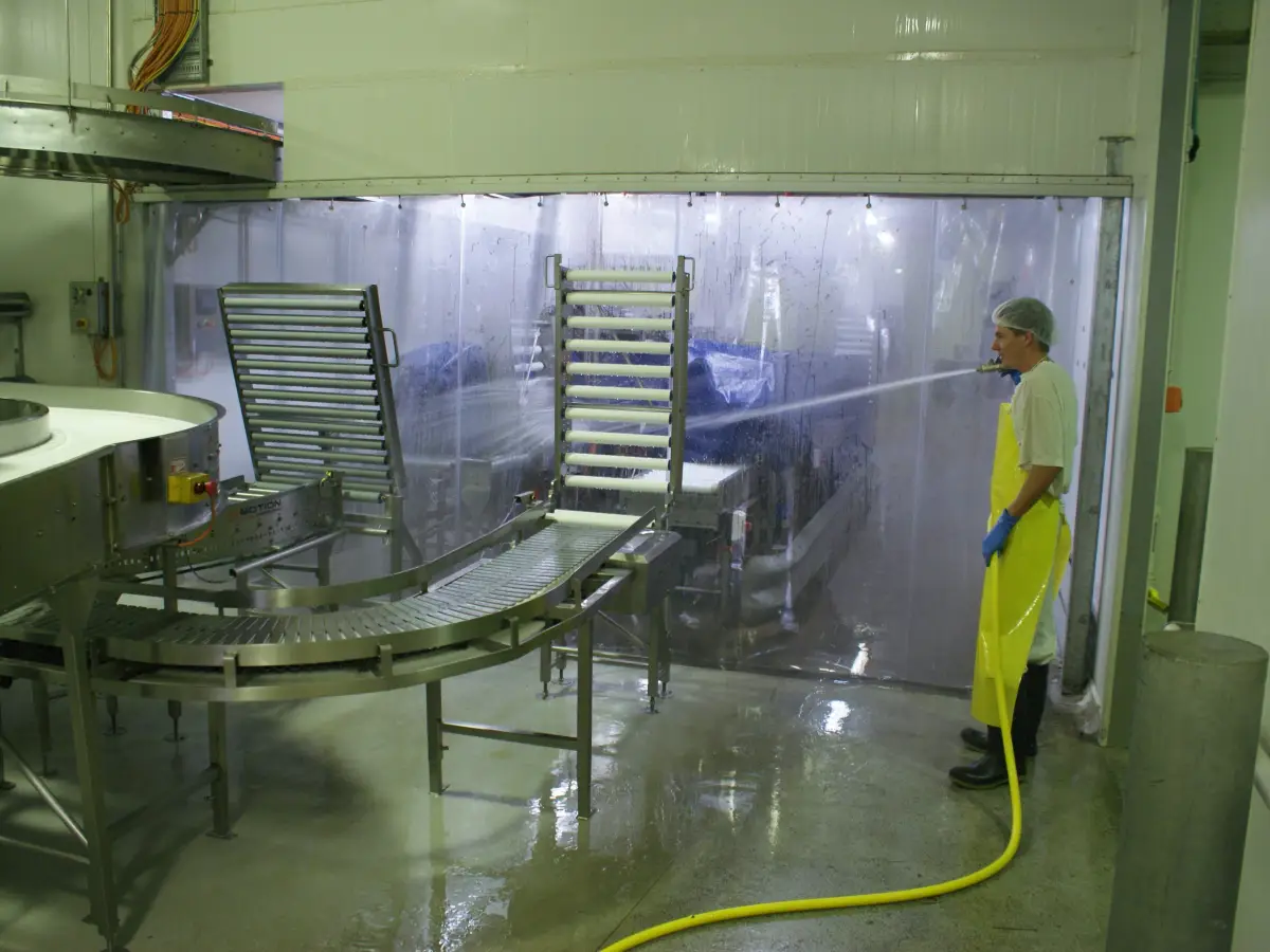 A industrial PVC screen; clear plastic curtains separating a wash down area in a commercial food processing factory