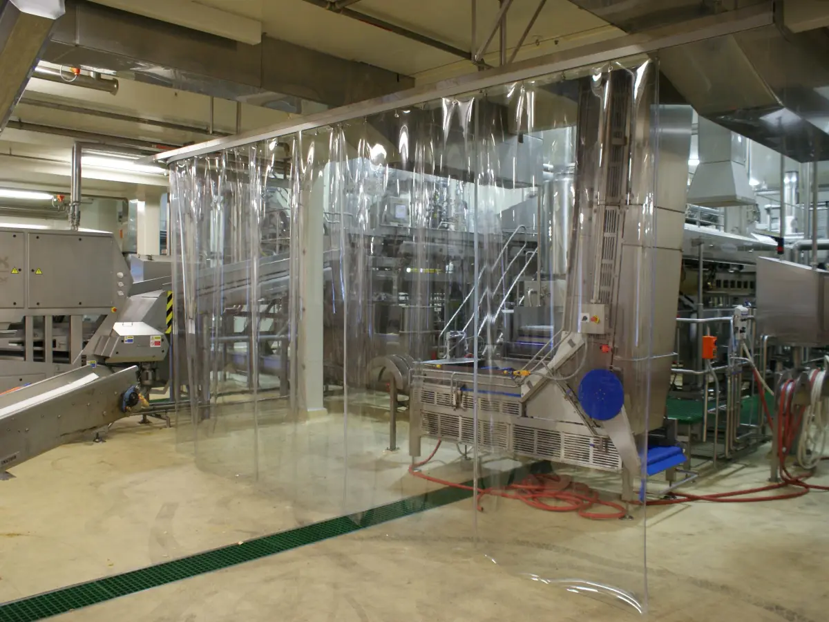 A clear plastic, PVC strip screen; industrial strip curtain used to protect factory equipment in commercial manufacturing facility