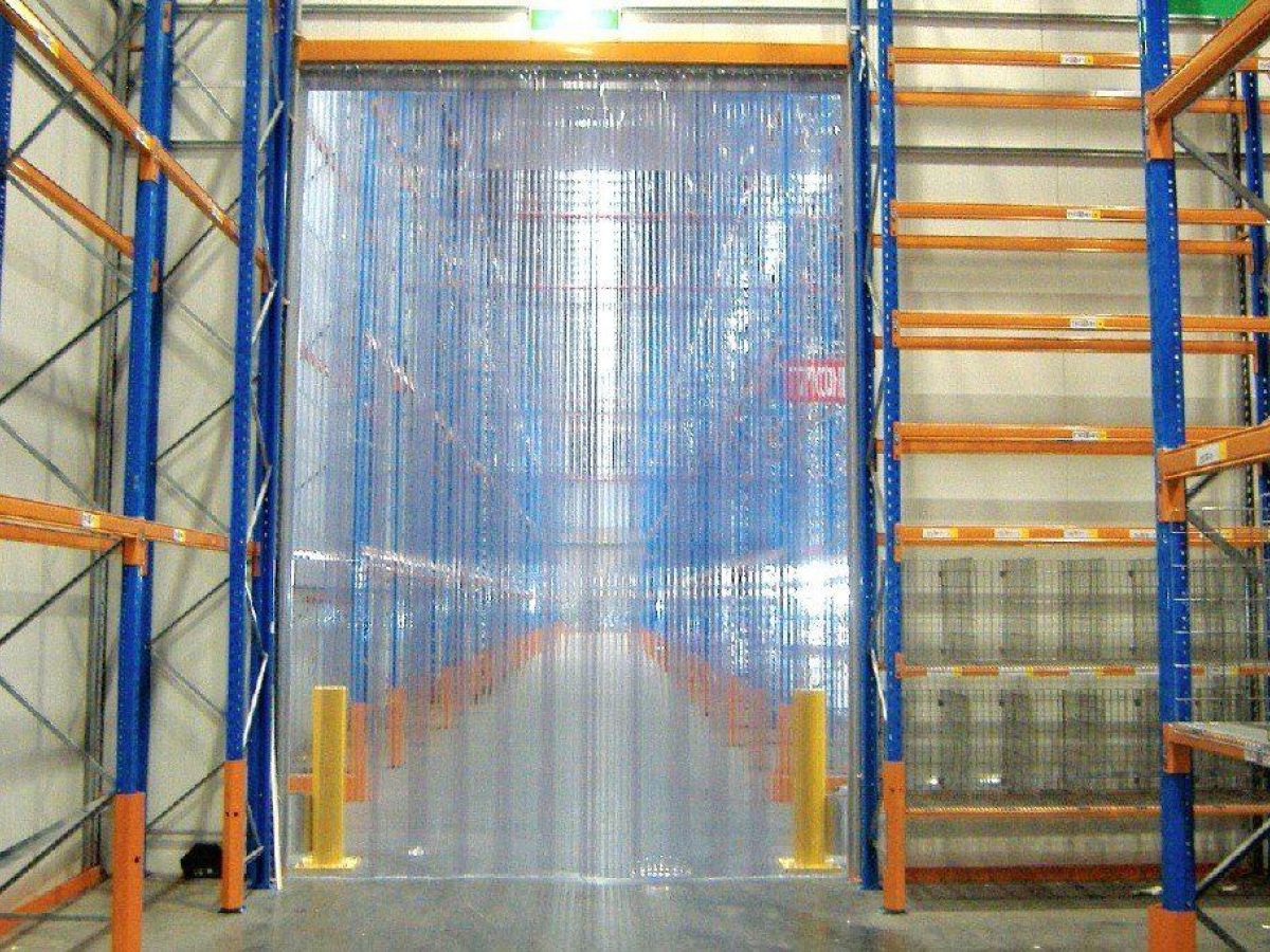 A PVC strip curtain in a freezer environment in a warehouse.