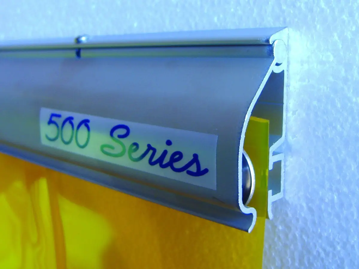 A yellow PVC strip curtain shown on a 500 Series strip curtain mounting system.