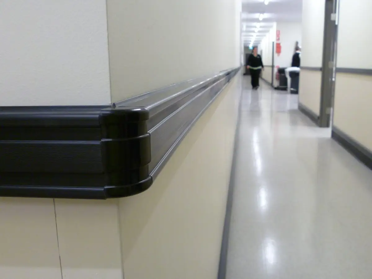 Bump rail wall protection system; Black plastic PVC bump rails protecting walls inside a healthcare facility