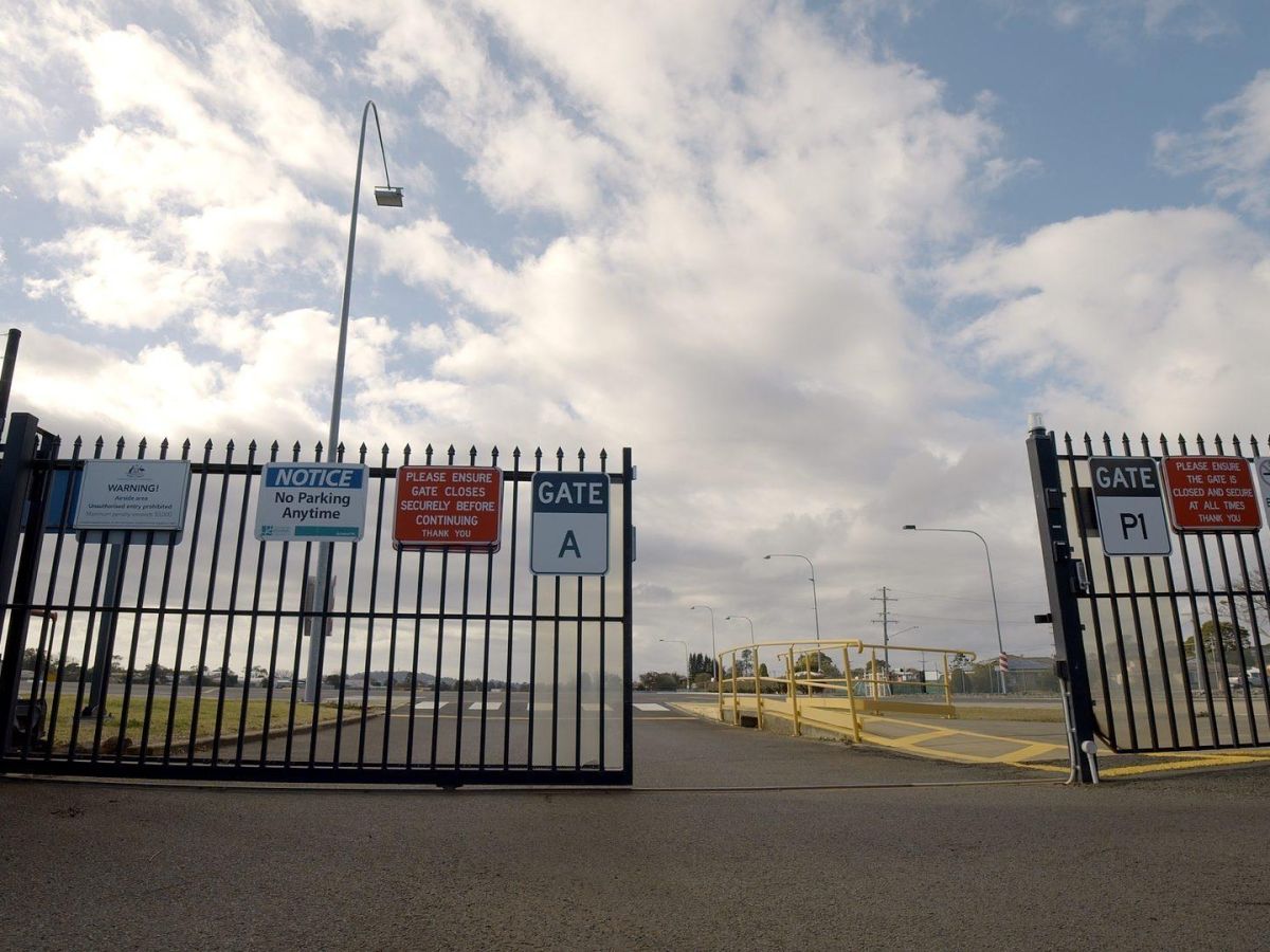 A black metal automatic commercial gate half open; sliding electric gate with seamless integration
