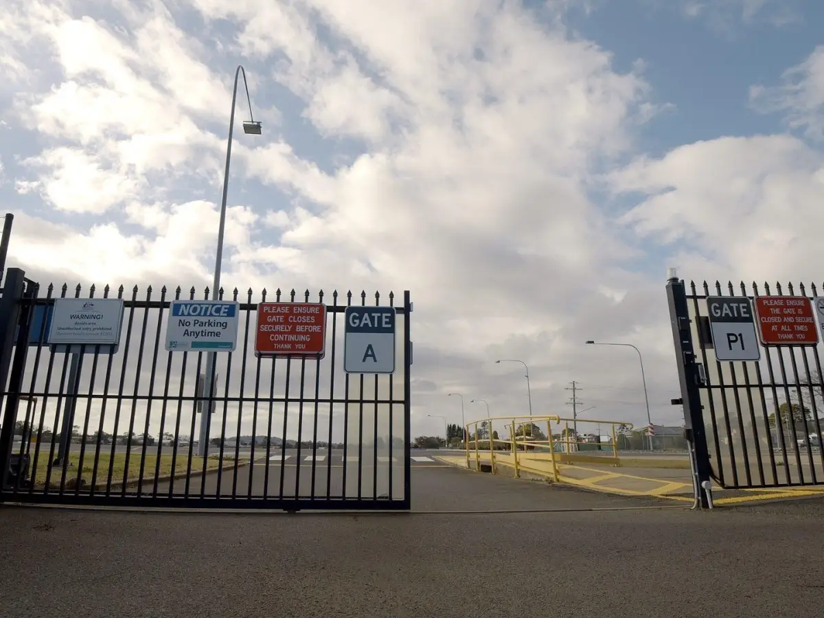 A black metal automatic commercial gate half open; sliding electric gate with seamless integration
