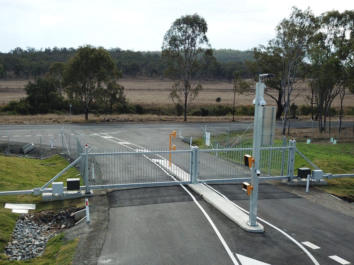 A closed automatic metal gate at a large industrial facility in Cooya; swing gate shown with centre open