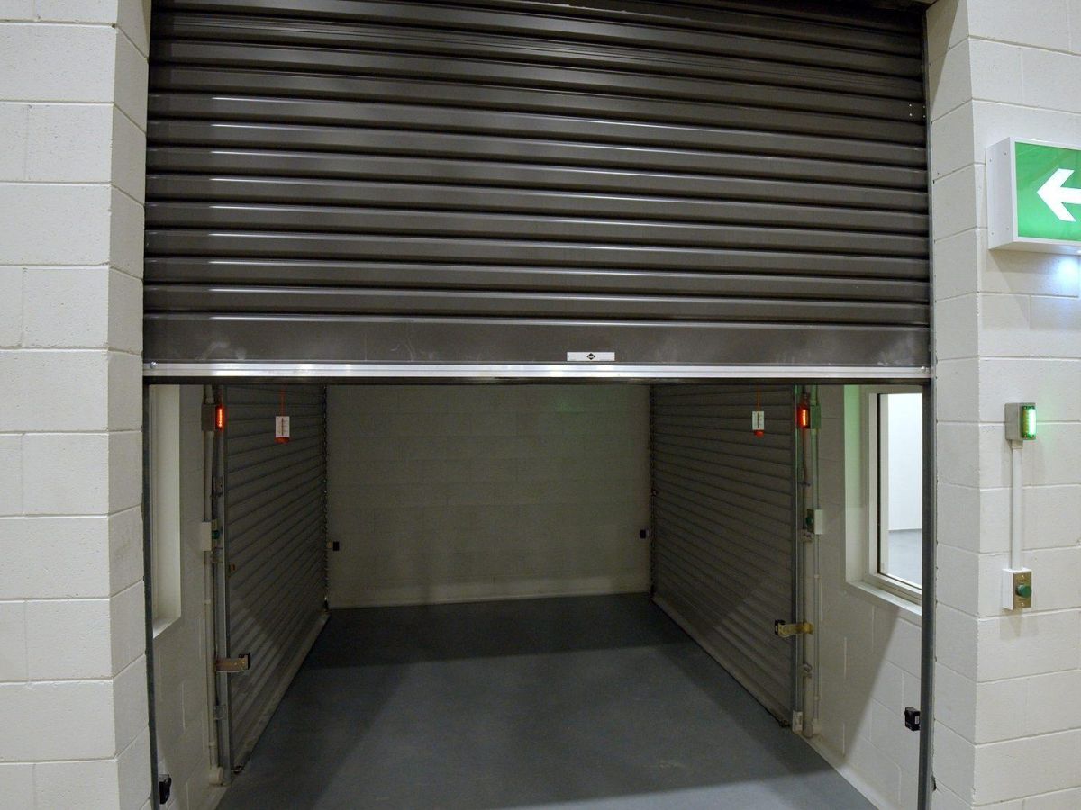 A half open roller shutter inside an industrial building.