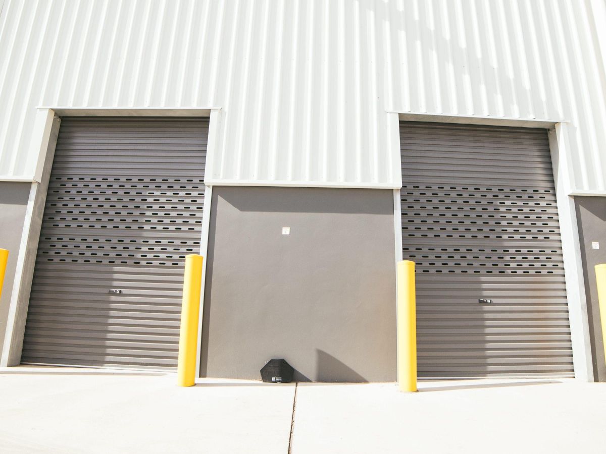 Two closed roller shutters on an industrial building.