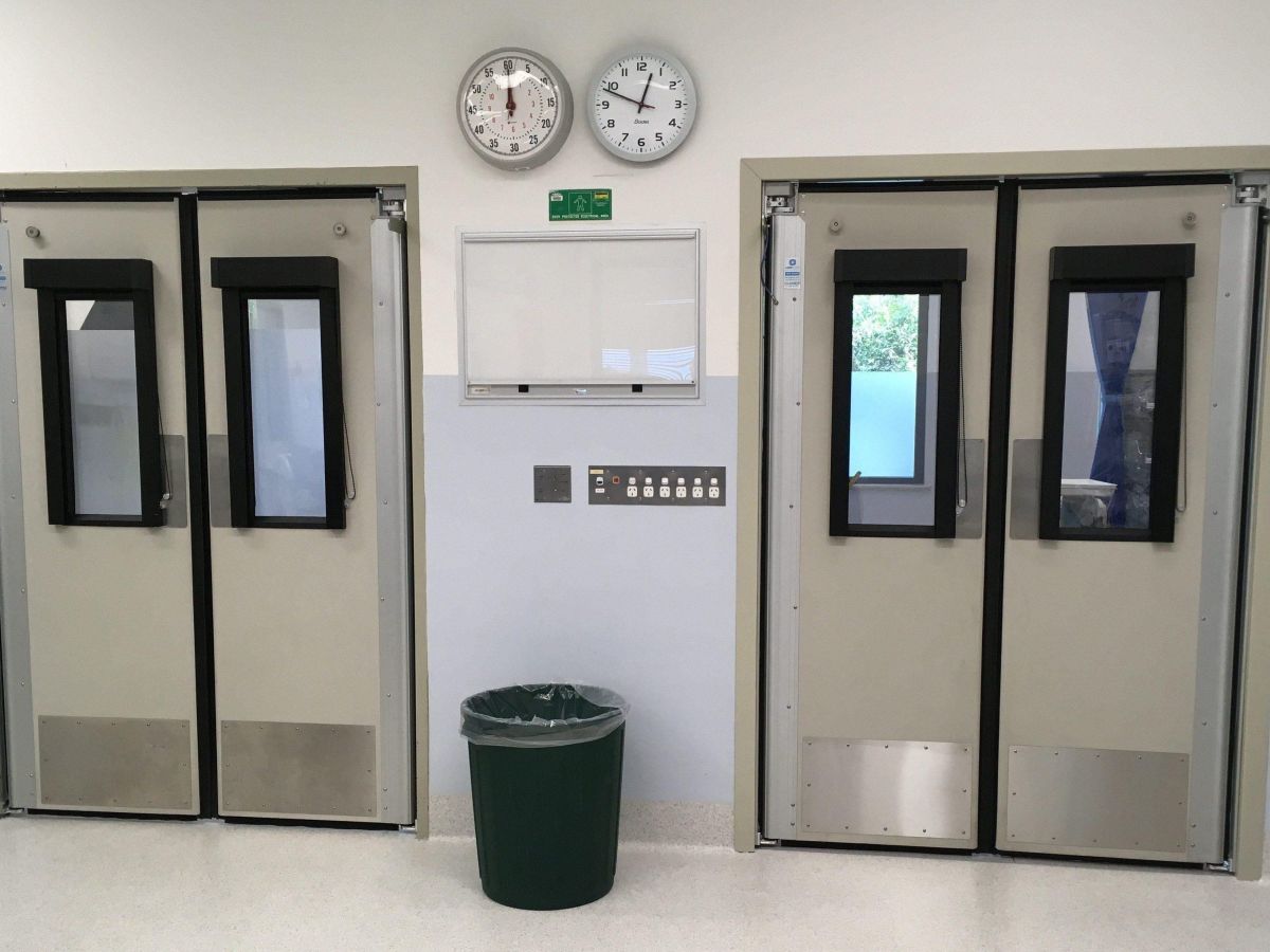 Two sets of swinging traffic doors in a hospital.