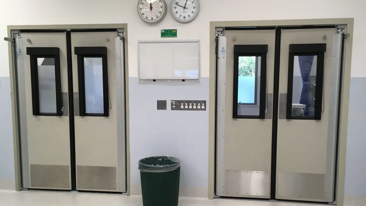 Two sets of swinging traffic doors in a hospital.