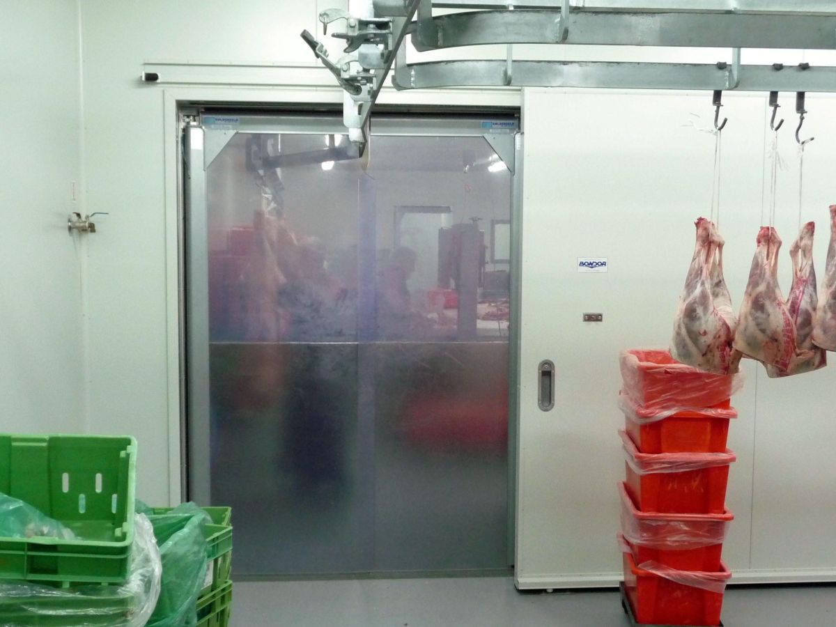 Flexible PVC swing doors in a meat processing factory.