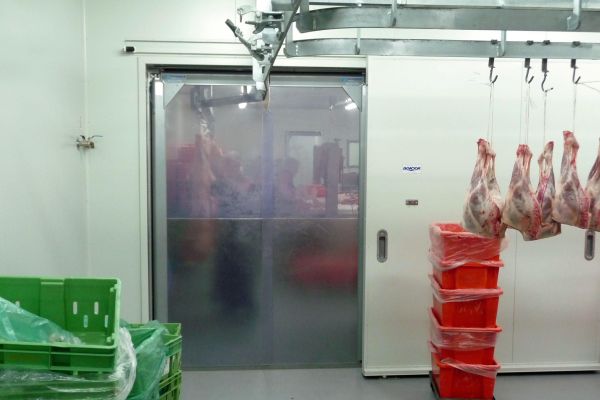 Flexible PVC swing doors in a meat processing factory.