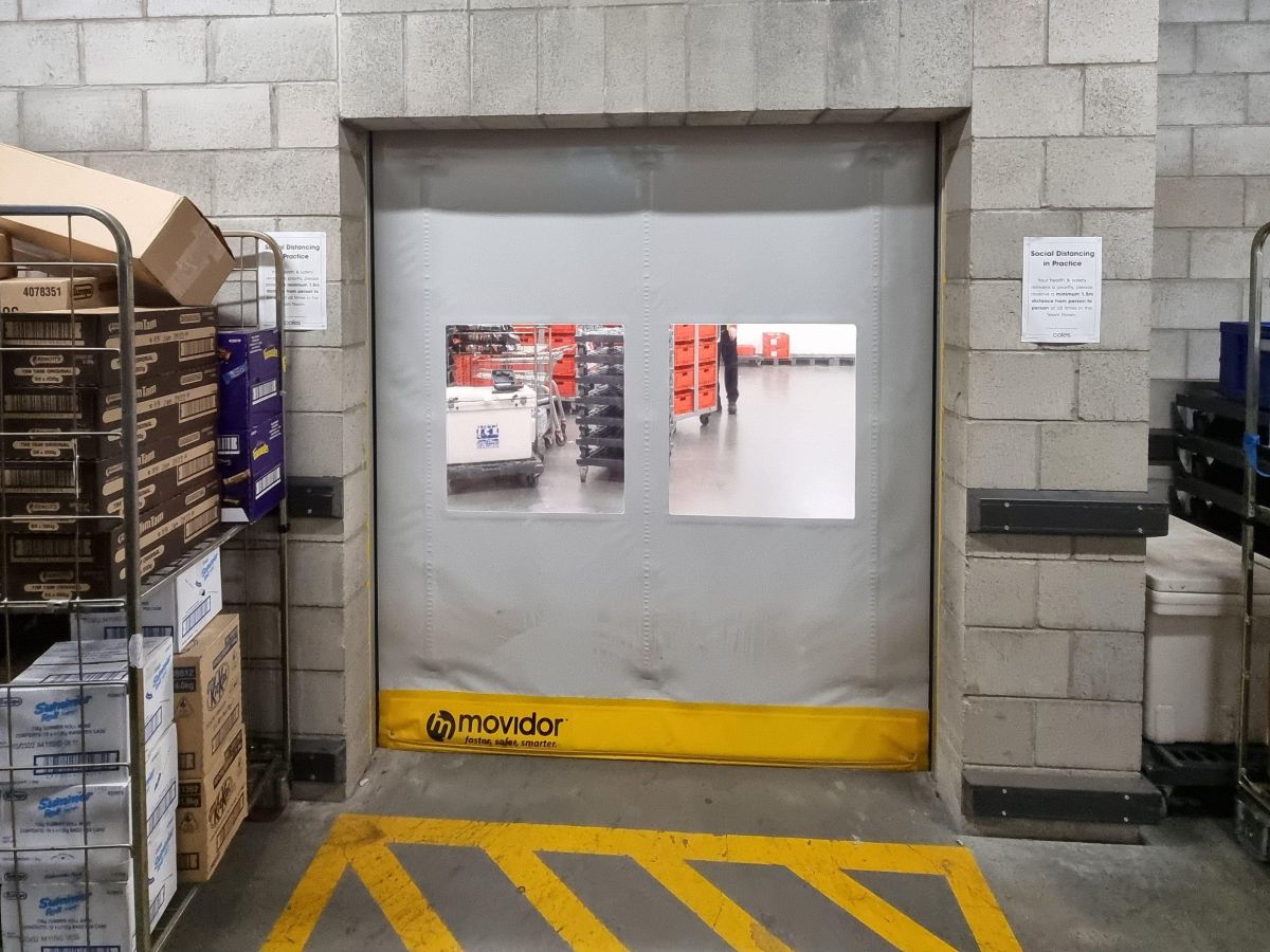 A grey high speed door inside a supermarket loading dock area.