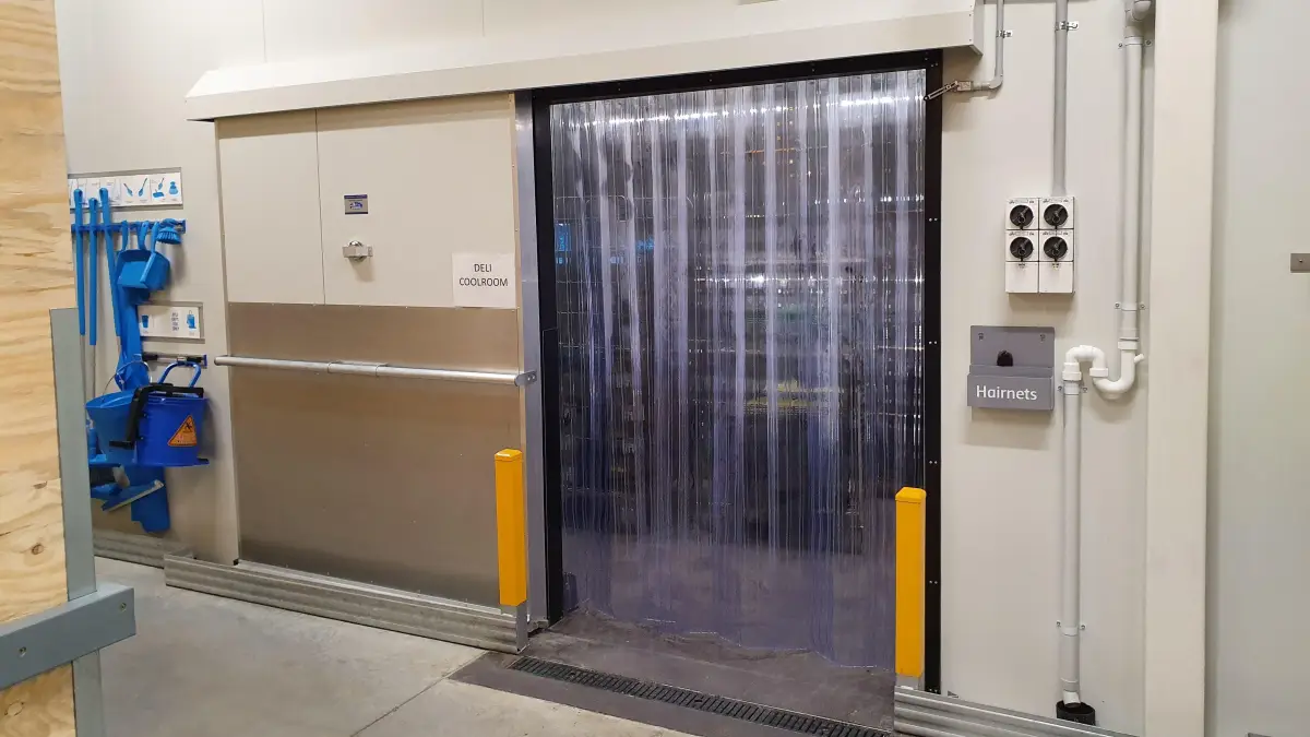 PVC strip curtain with custom wall mounting system on an insulated automatic sliding door within Coles Rochedale.