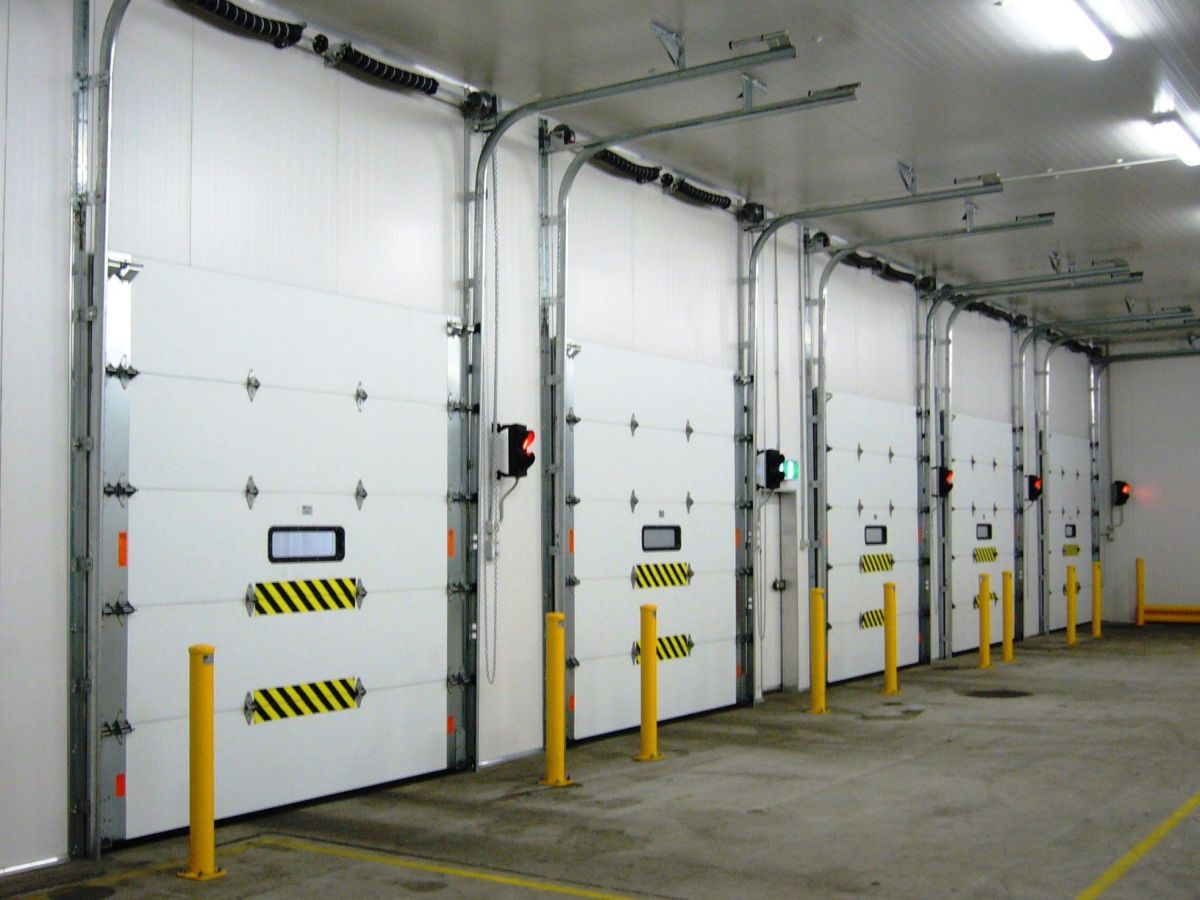 Five closed sectional doors inside a factory.