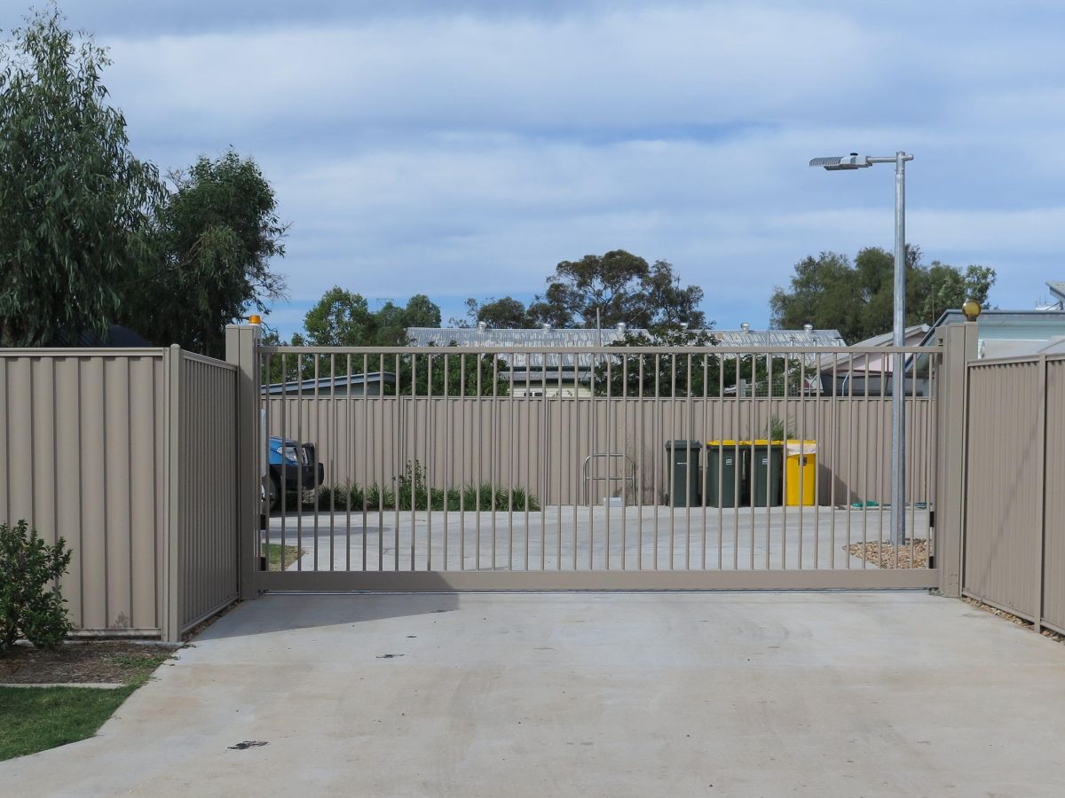 A closed automatic sliding gate at an emergency services carpark.