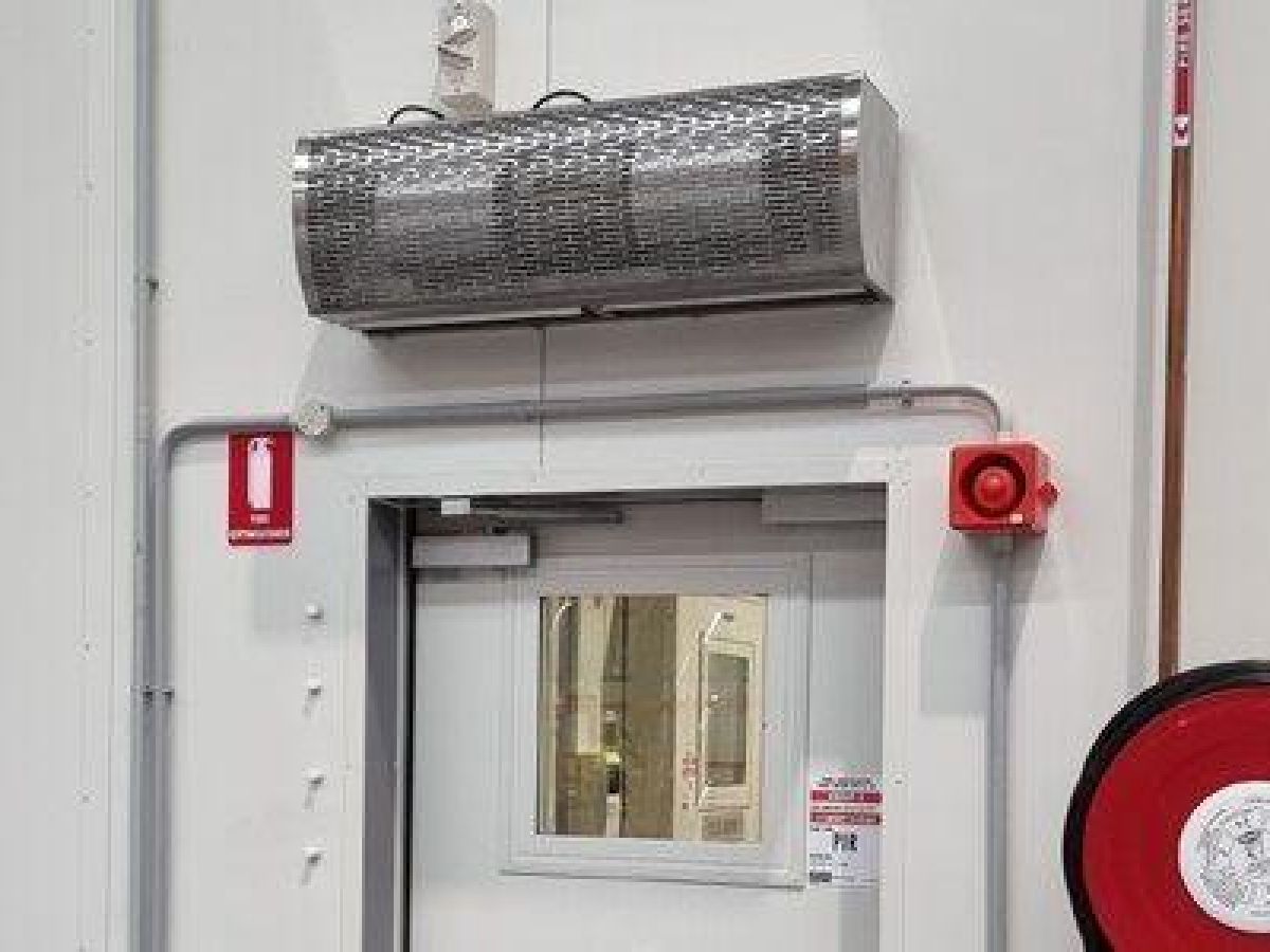 An industrial air curtain above a door in a manufacturing factory.