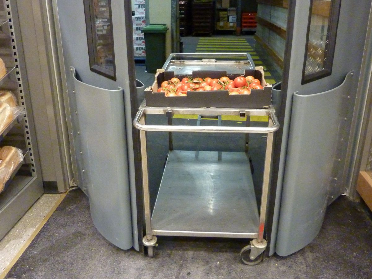 A trolley going through open traffic swing doors in a supermarket.