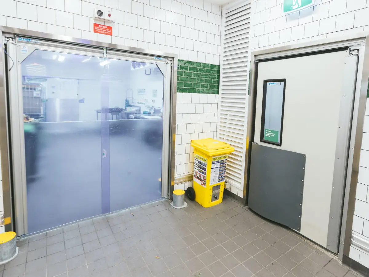 A PVC swing door and traffic door in a supermarket stock area.